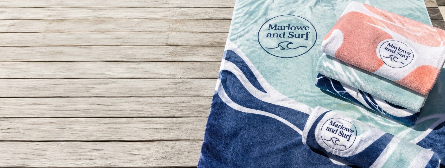 Custom printed beach towels with logo on a poolside lounger
